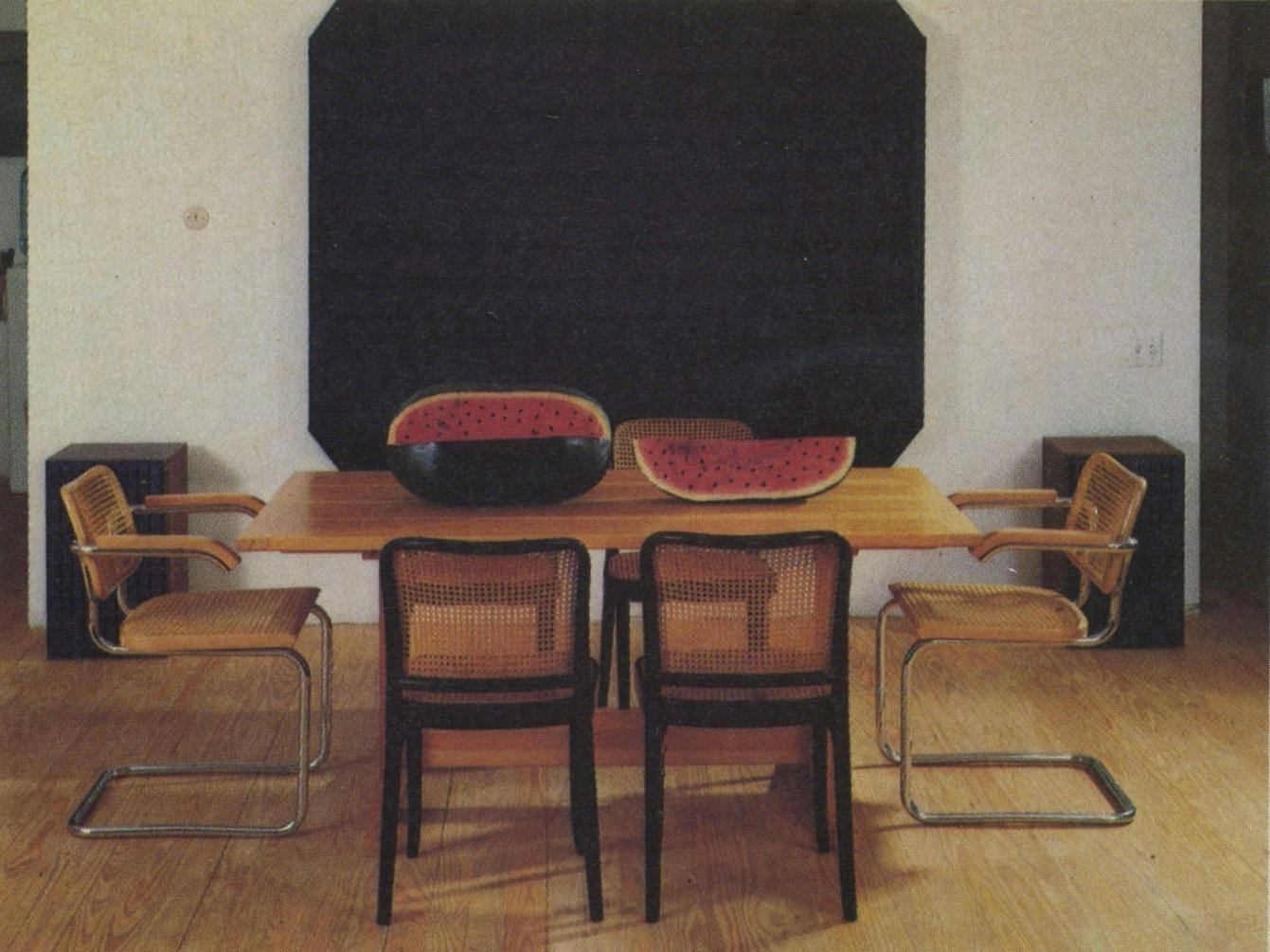 Ralph Humphrey’s heavily textured black oil provides a dramatic background for the colorful watermelon centerpiece carved from cottonwood and painted by Felipe Archuleta. Around the table are original Cesca (light) and Thonet (black) chairs.