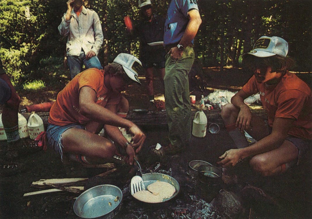 Boy scouts cooking over an open fire. 