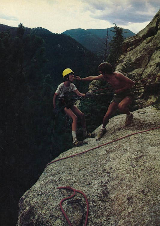 Rock climbing boy scouts on the edge of a cliff. 
