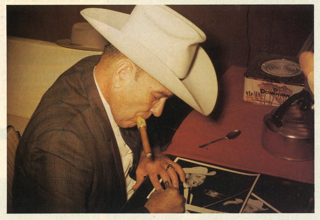 1966: Swing king Bob Wills takes a break from performing to smoke a cigar and sign some autographs at the New Cotton Club. 