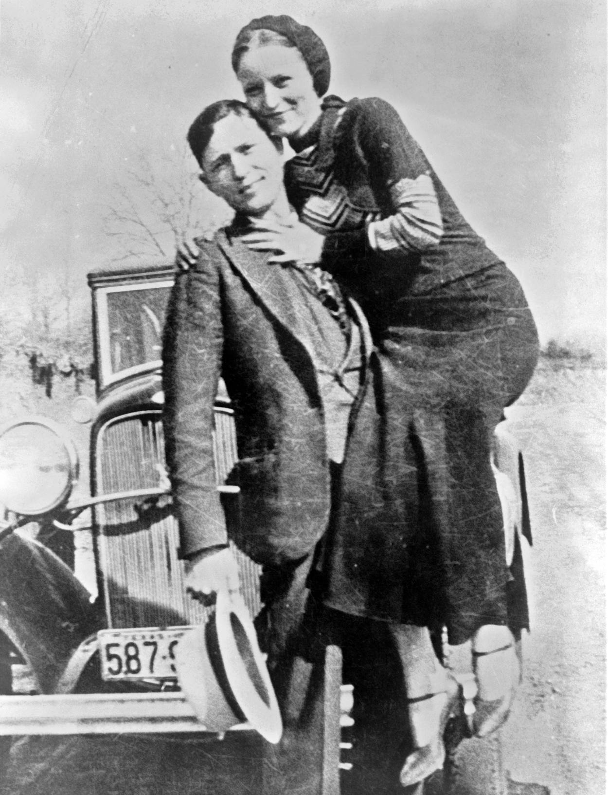 Clyde holding Bonnie in black and white photograph.