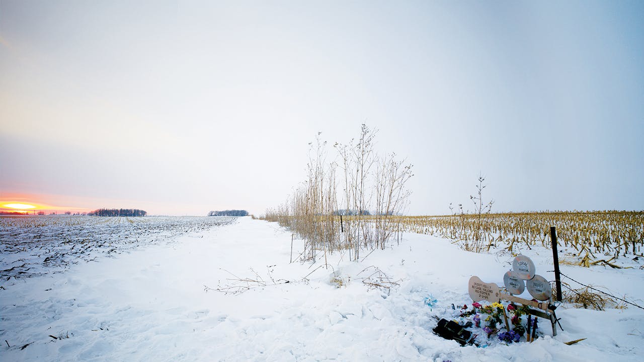 A Buddy Holly memorial on an isolated, snow-covered field. 