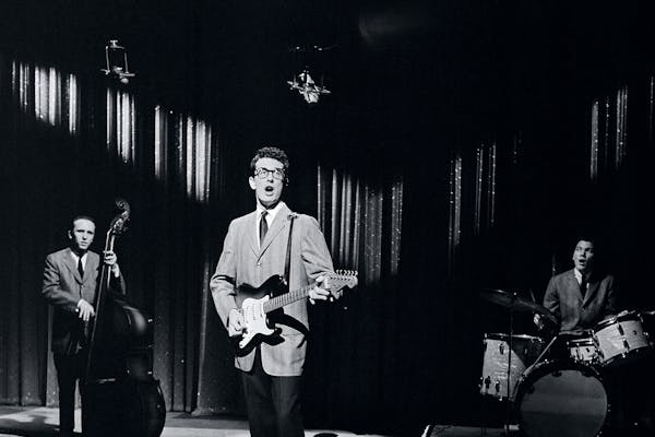 Black and white image of Bobby Holly performing in a spotlight. 