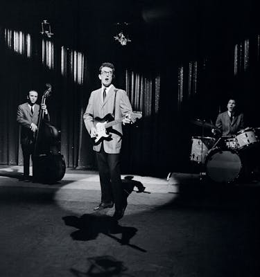Black and white image of Bobby Holly performing in a spotlight. 