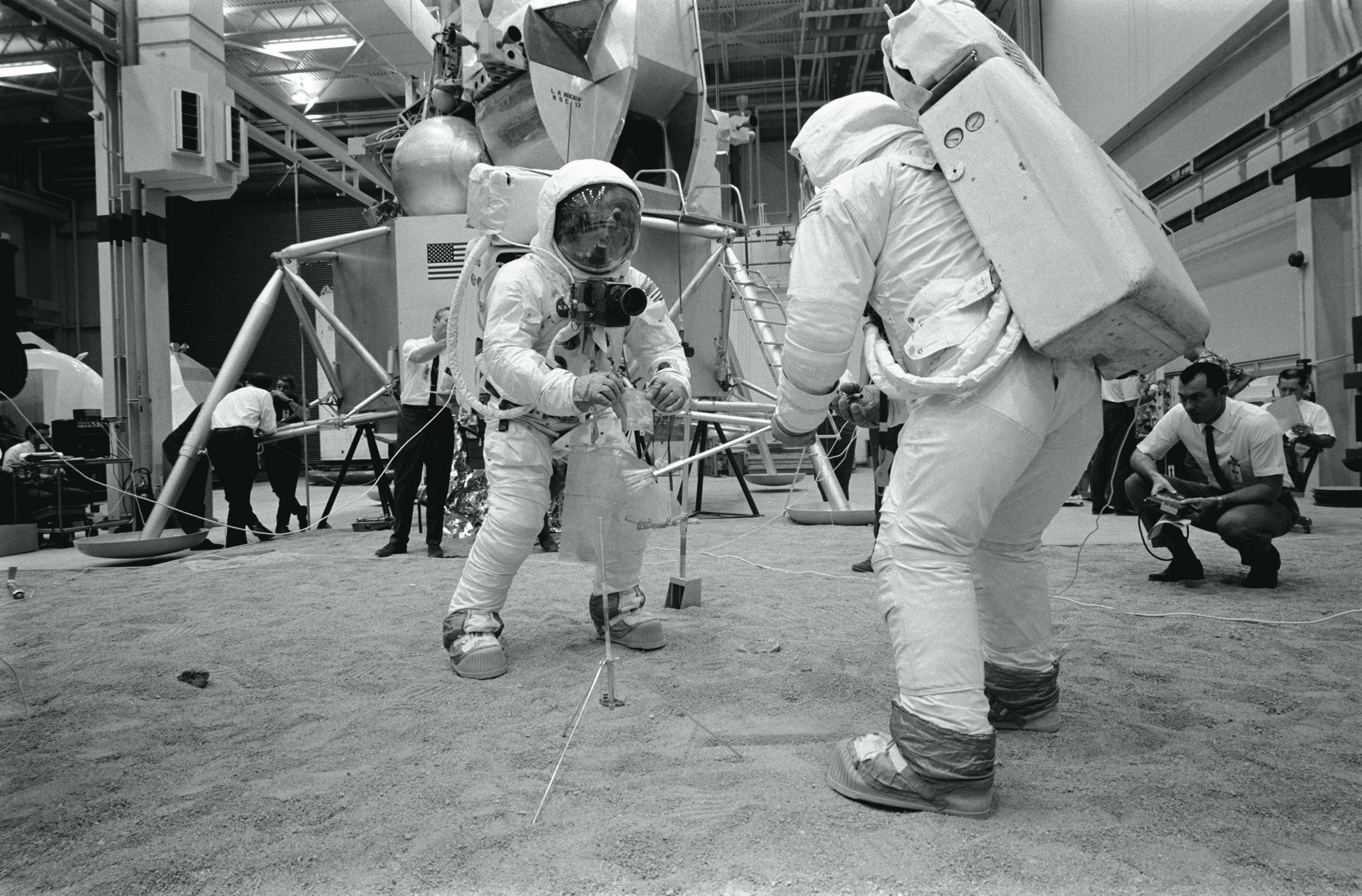 Armstrong and Aldrin practice taking lunar samples. 