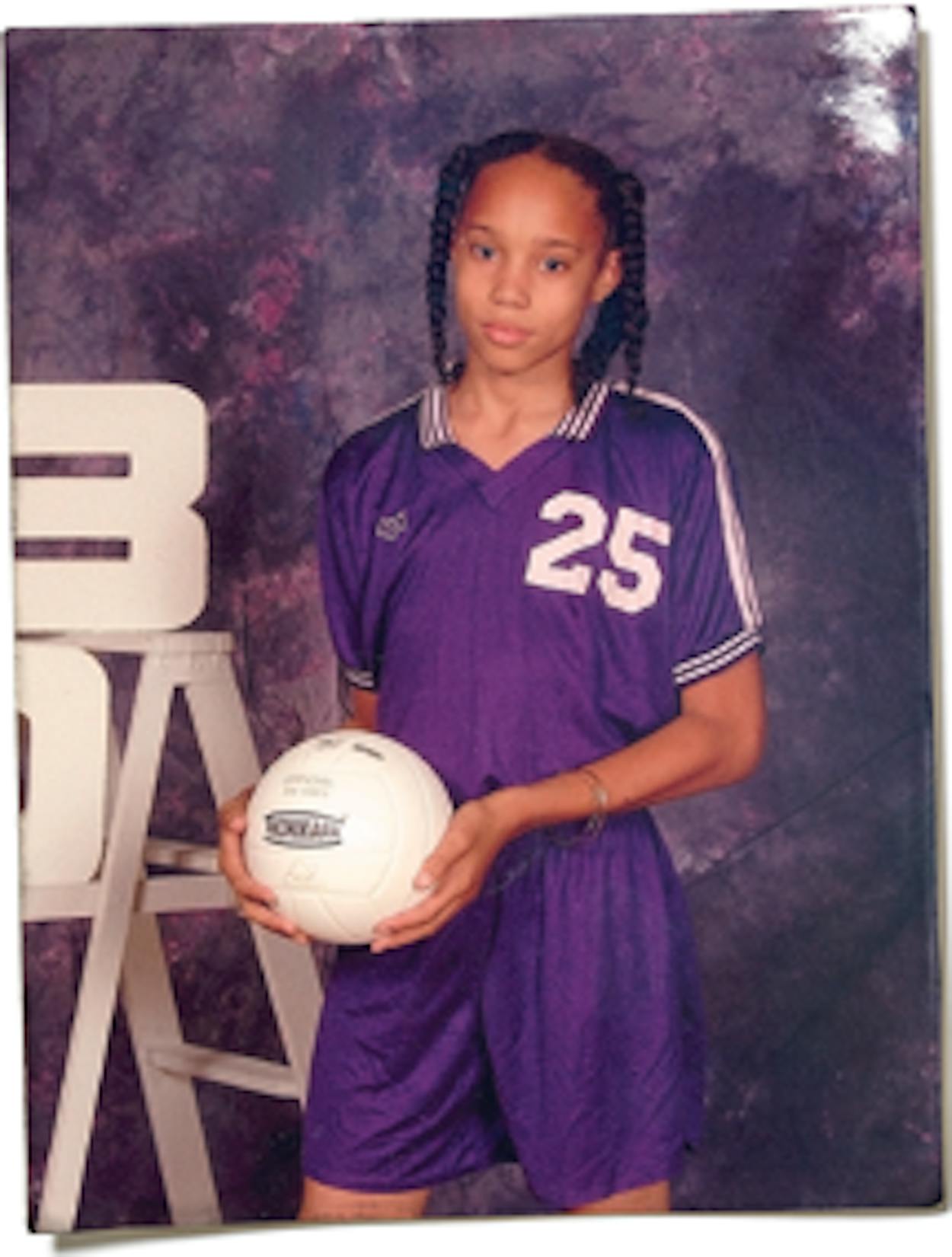 Brittney Griner in seventh grade, posing with a volleyball in her team uniform.