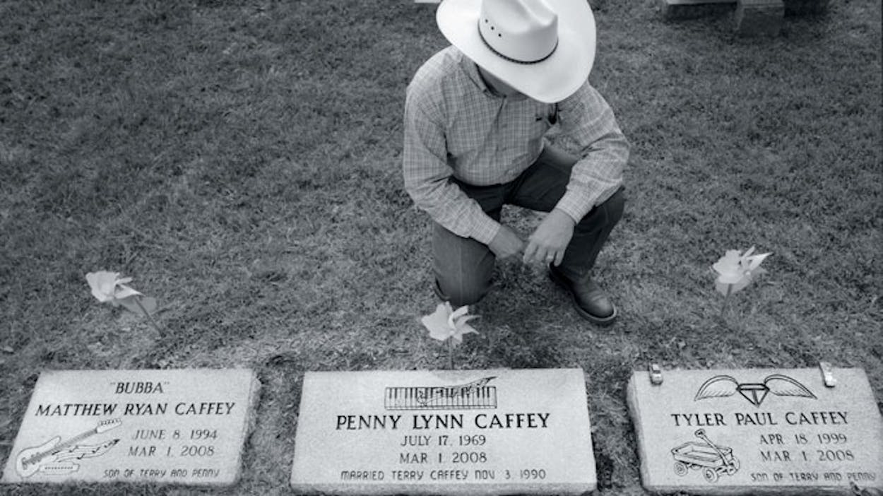 Terry Caffey kneeling in front of his wife and sons' graves.