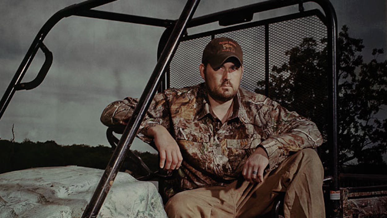 Marcus Luttrell, dressed in camo, on his in-laws ranch vehicle.