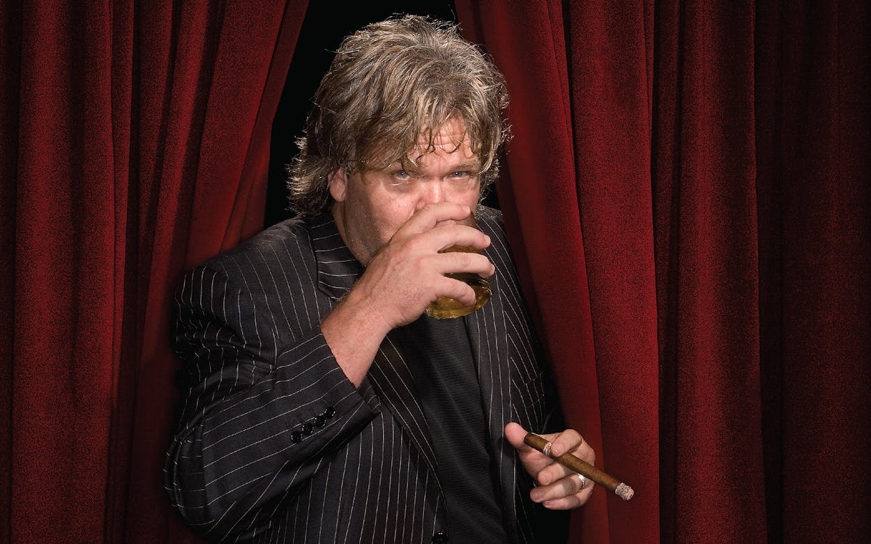 Ron White drinking whiskey on stage.