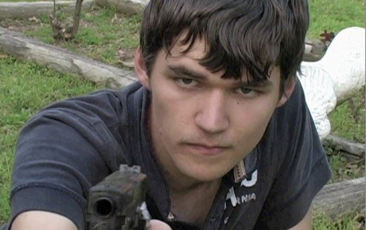 Trey Sesler staring into the camera and pointing a gun at it.