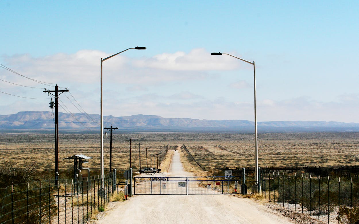 Remote-controlled gate on a long country road.