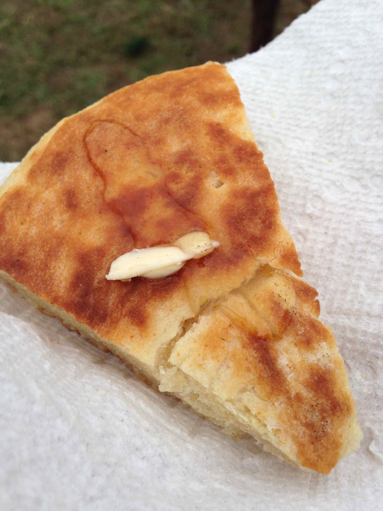 Triangular slice of pan de campo with melted butter. 