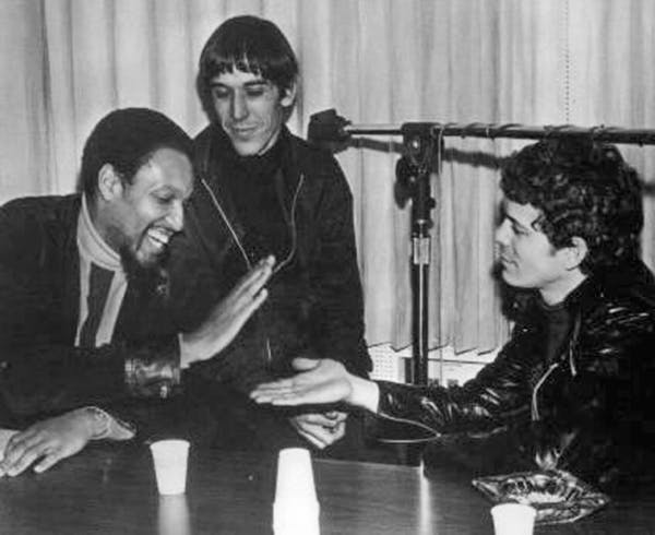 Wilson low-fives Lou Reed as Velvet Underground bandmate John Cale looks on during taping of MGM underground radio promotional disc The Factory, 1968.