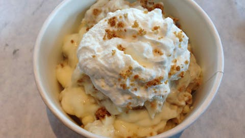 Whipped cream and Nilla Wafer crumbs on top of banana pudding. 