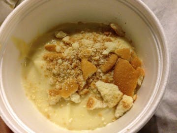 Yellow banana pudding topped with crumbled cookies. 
