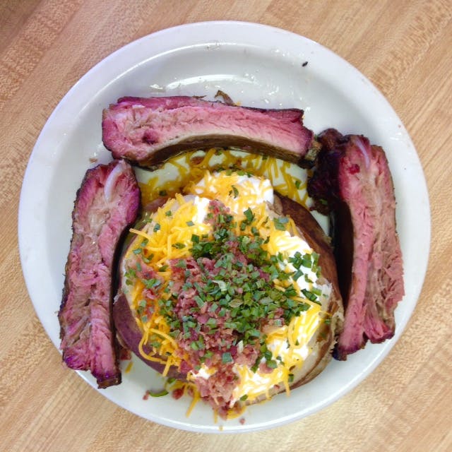 Classic, overflowing baked potato served with pork ribs. 