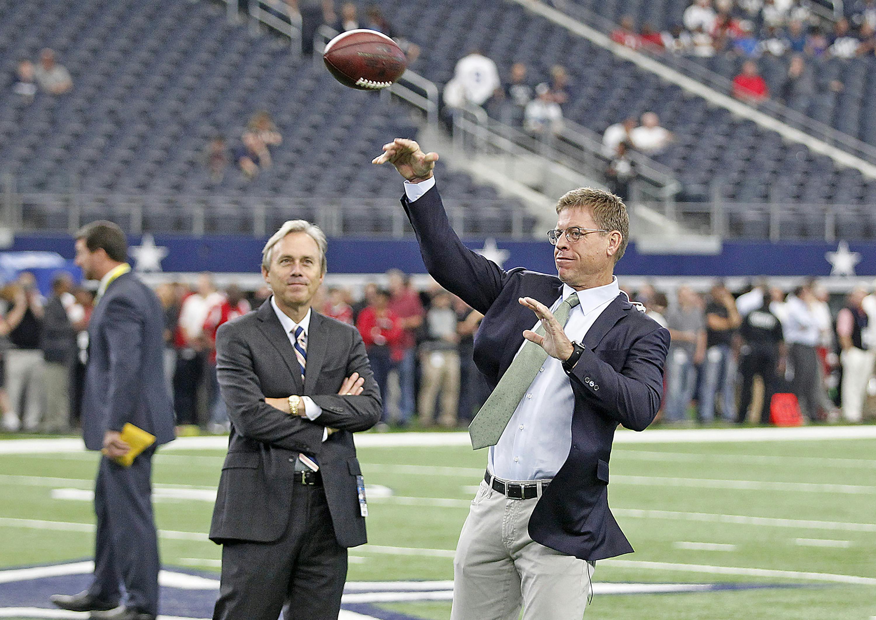 Fox Sports announcer Troy Aikman passes before an NFL game between the Dallas Cowboys against the Atlanta Falcons at AT&T Stadium in Arlington, Texas, Sunday, September 27, 2015.   The Falcons defeated the Cowboys, 39-28.  (James D. Smith via AP)