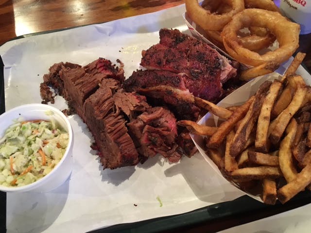 BBQ platter of brisket, french fries, onion rings, and cole slaw. 