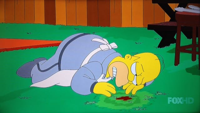 Homer Simpson lying on the grass where his smoker used to sit. 
