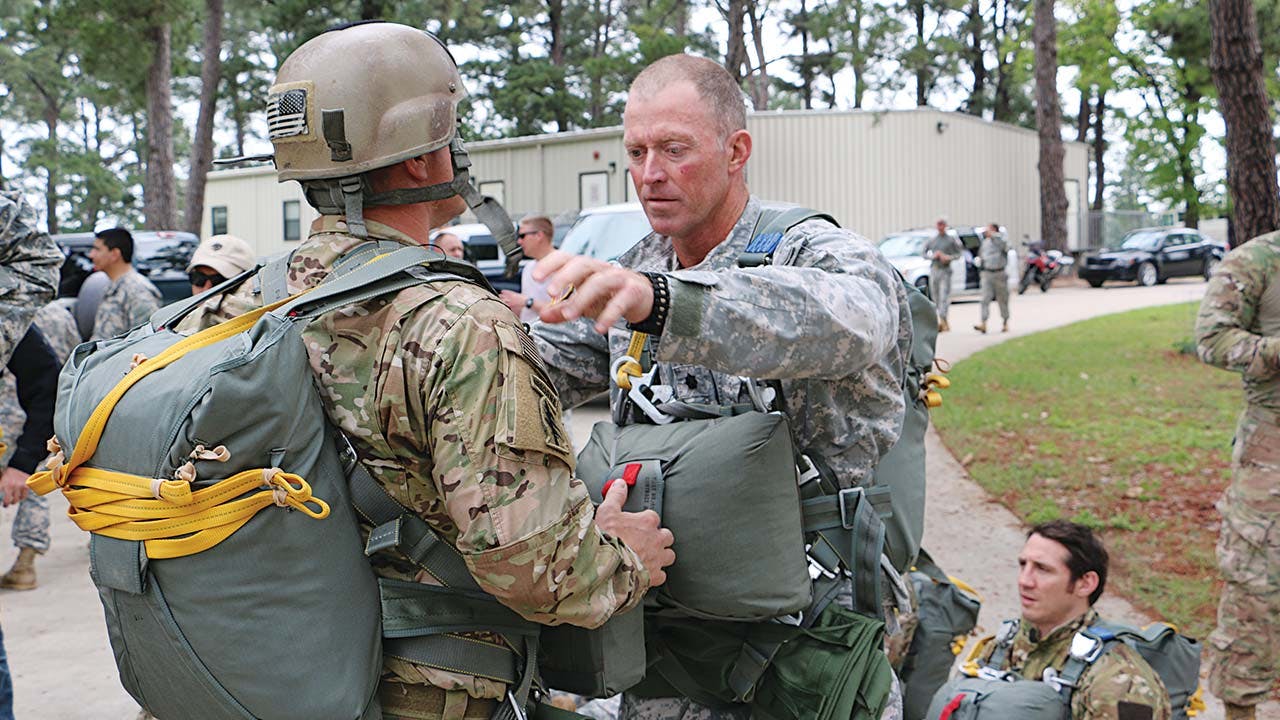 Tim Ochsner inspects one of his soldiers’ parachute riggings.