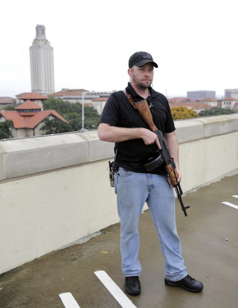 Gun rights activist Michael Short holds a gun as he prepares for a march near UT.