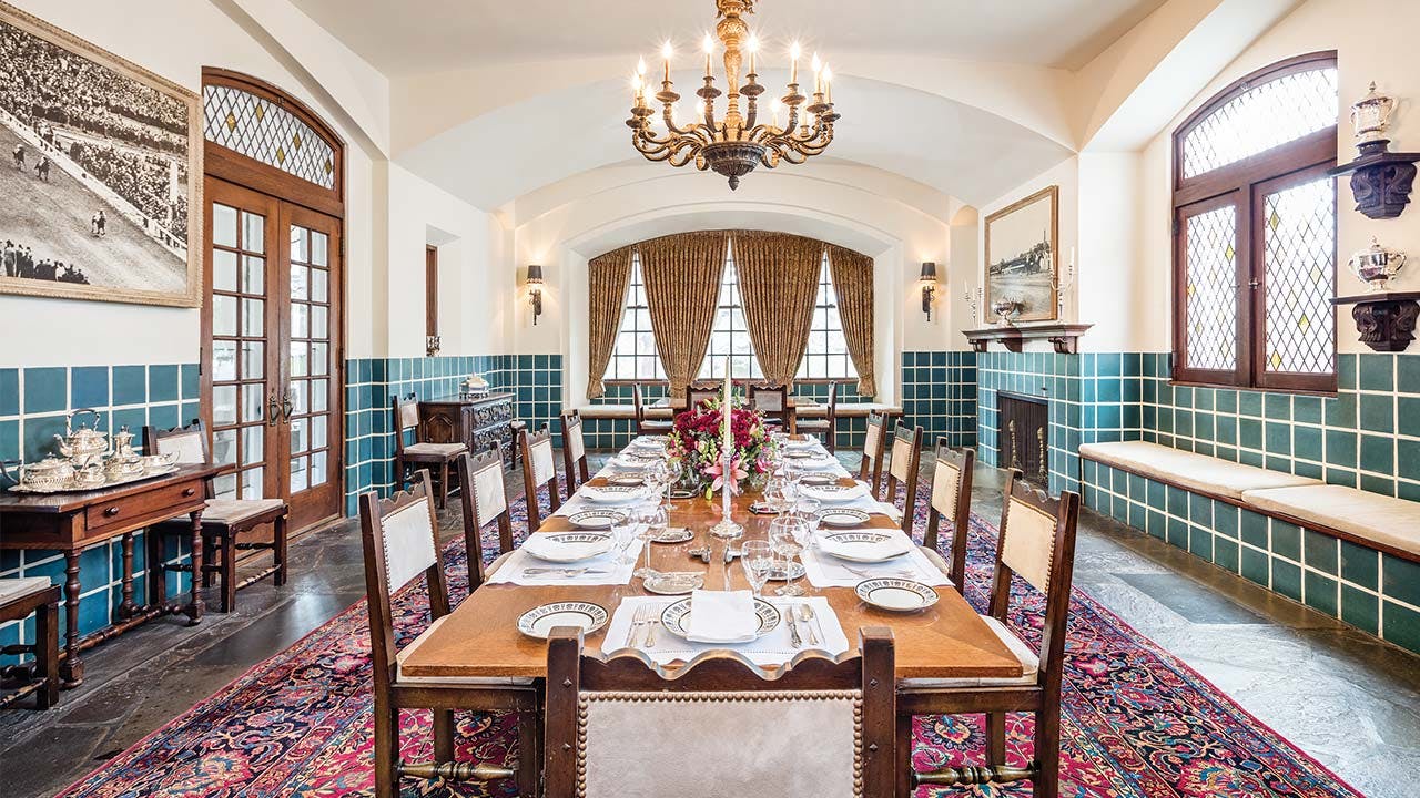 The formal dining room, with the table and chairs made by Tiffany, features blue-green tile wainscoting that was specially made at Henrietta's request. For grand occasions the table can seat fifty. 