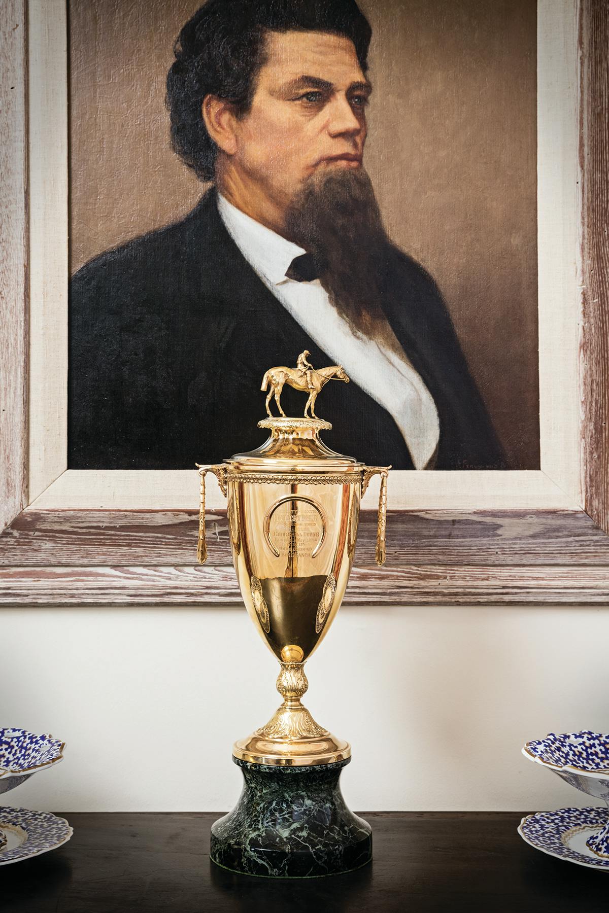 A painting of Captain Richard King above a Kentucky Derby.