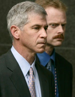 FILE - In this March 13, 2006 file photo, former Enron CFO Andrew Fastow, left, is escorted away from the federal courthouse by an officer in Houston at the end of his final day of testimony in the fraud and conspiracy trial of former Enron executives Kenneth Lay and Jeffrey Skilling. (AP Photo/Pat Sullivan, File)