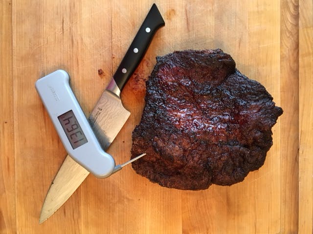 Unsliced brisket, with a meat thermometer showing the number 136.4. 