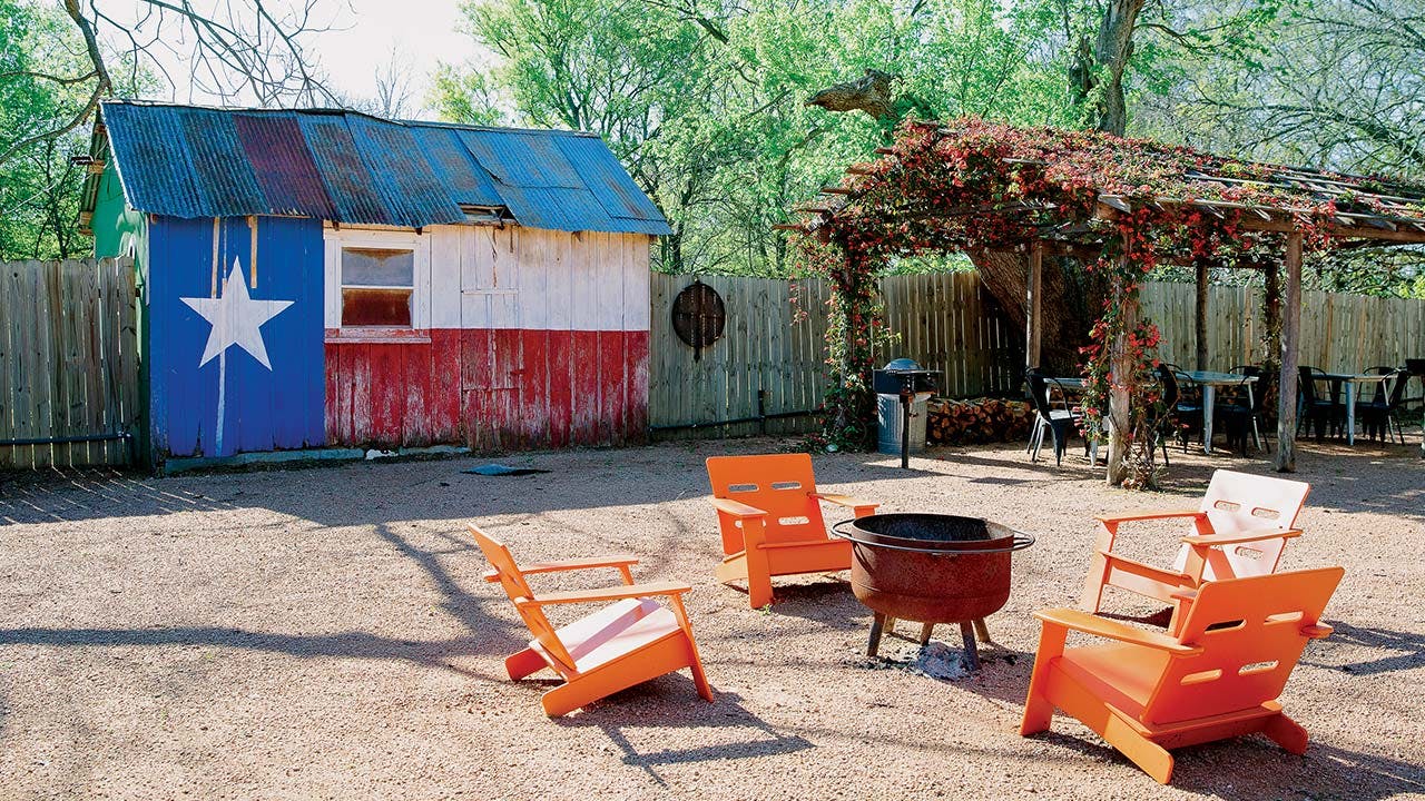 feature-WTSN-camp-comfort-exterior-fire-pit-chairs-texas-flag-building