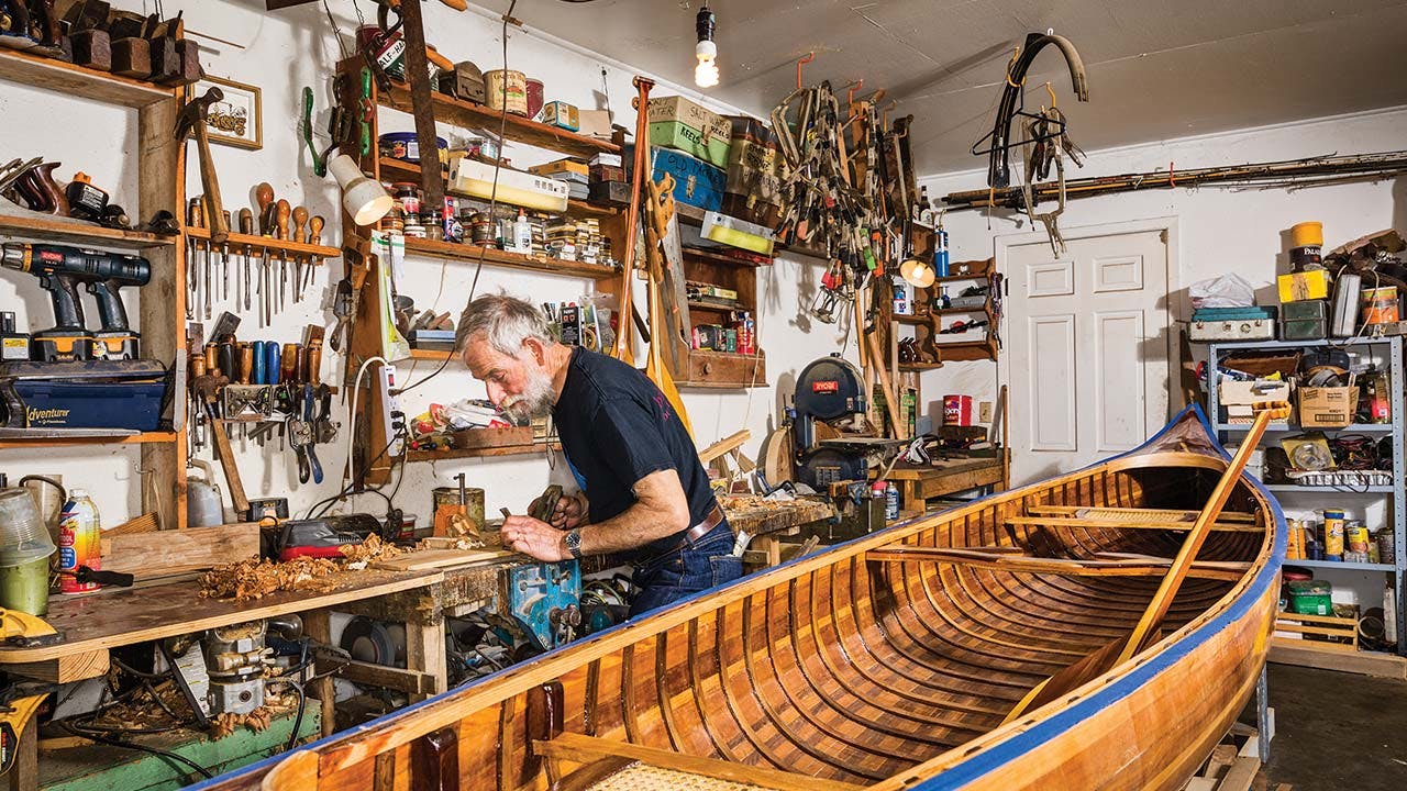 Bowen with a canoe awaiting its final sanding and varnish (boats start at $3,000).