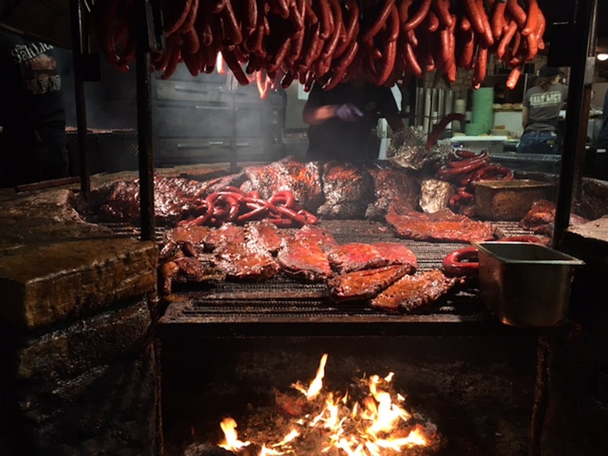 Salt Lick BBQ pit filled with smoking meats.