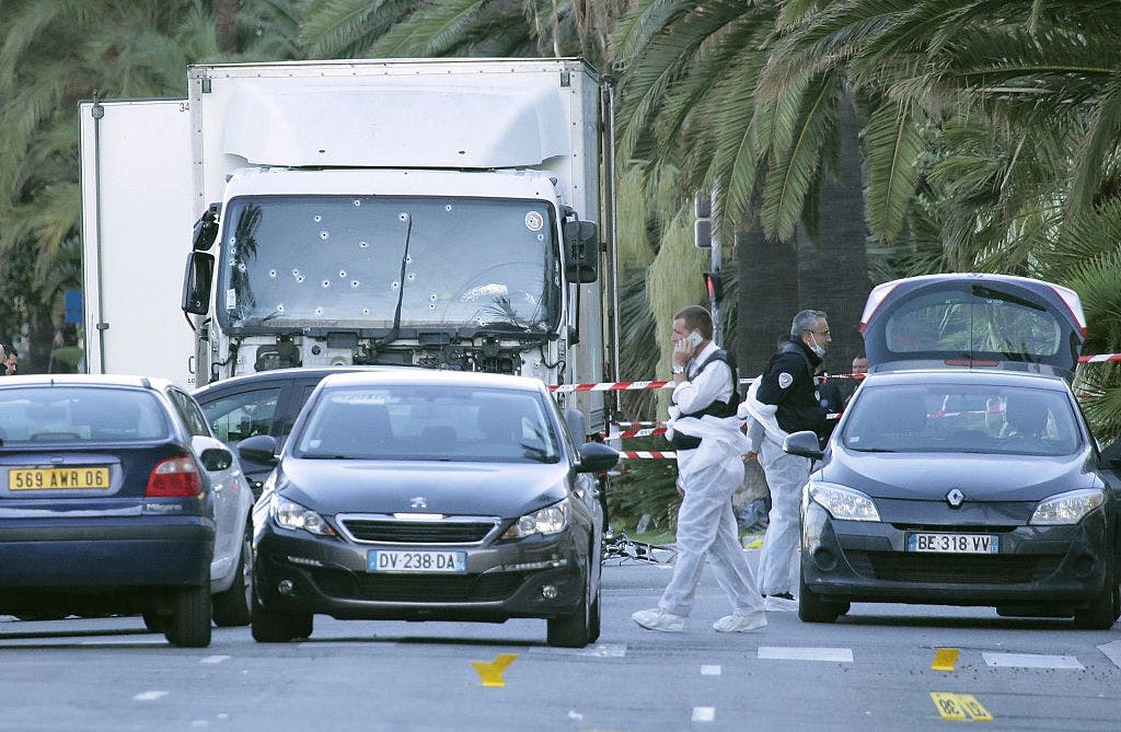 The police look for evidence near a truck on the Promenade des Anglais on July 15, 2016 in Nice, France. An attack in Nice where a man rammed a truck into a crowd of people left 84 dead. 