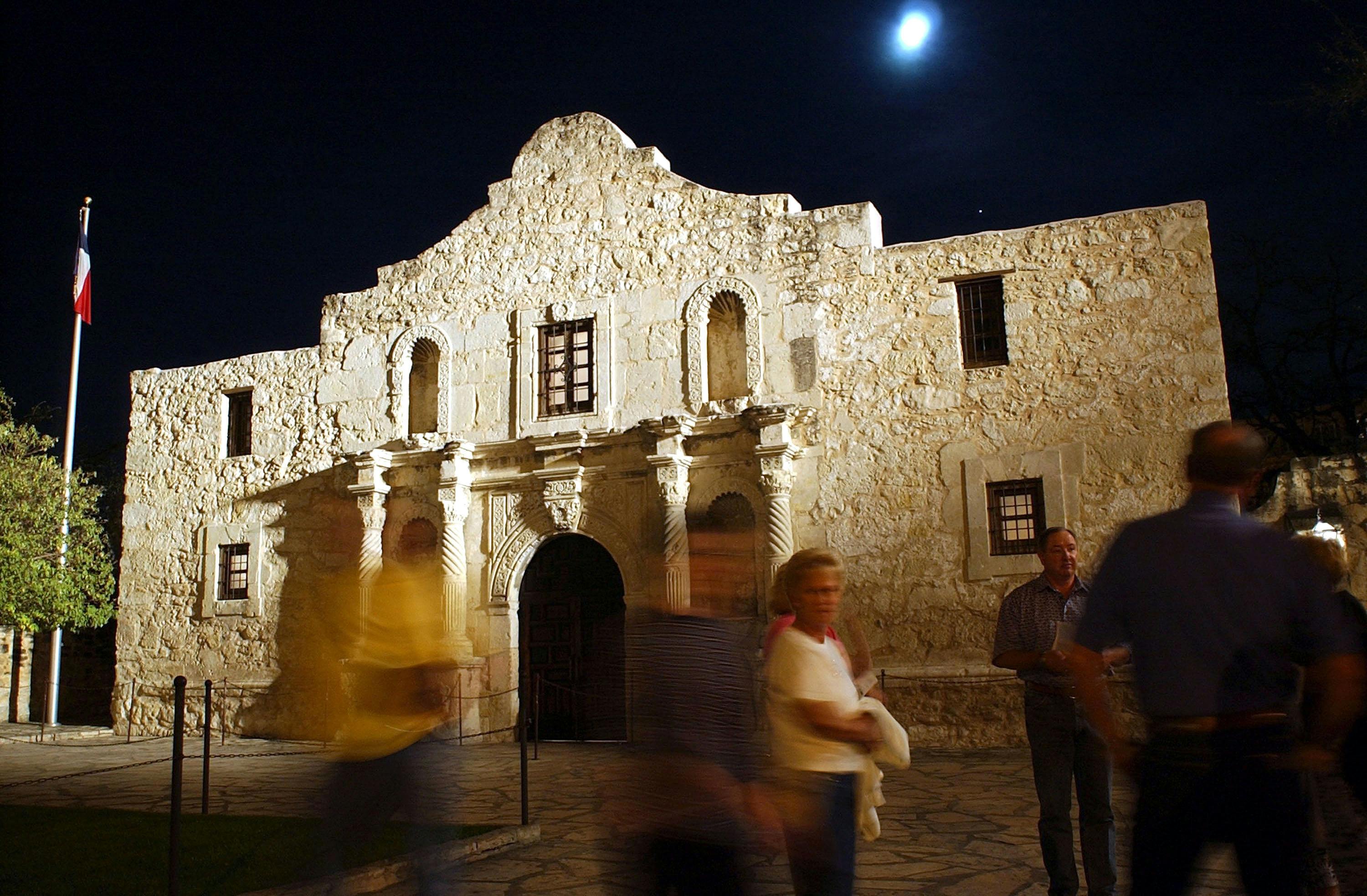 Visitors walk around outside of the Alamo the night before the 168th Anniversary of the 1836 Fall of the Alamo March 5, 2004 in San Antonio, Texas. 