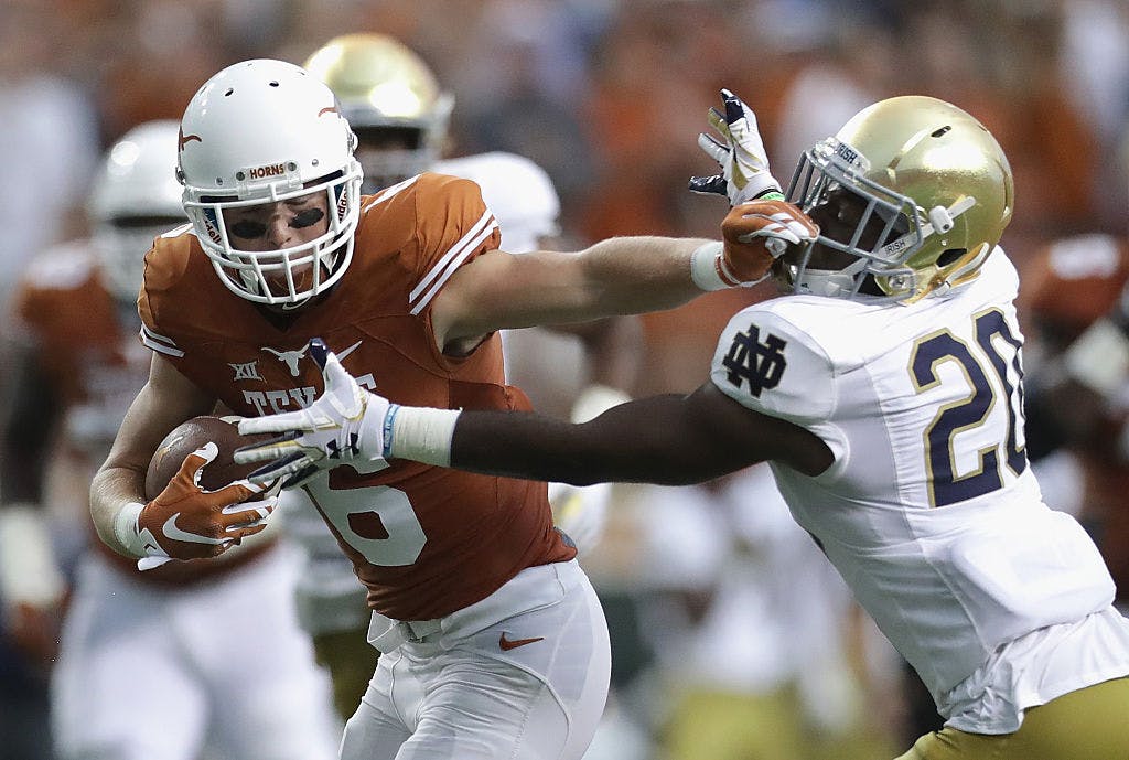 : Jake Oliver #6 of the Texas Longhorns stiff arms Shaun Crawford #20 of the Notre Dame Fighting Irish during the first half at Darrell K. Royal-Texas Memorial Stadium on September 4, 2016 in Austin, Texas.