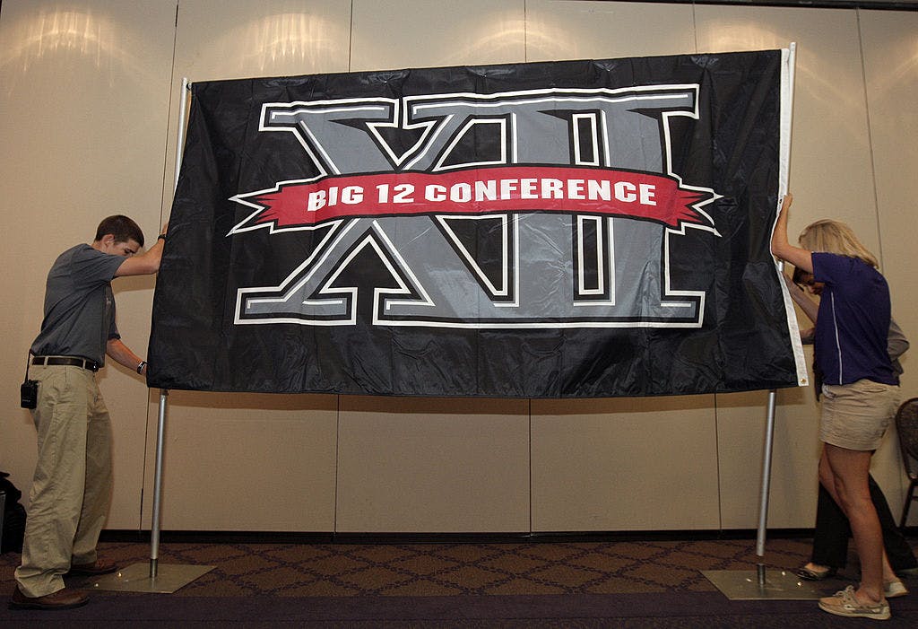 Texas Christian University sophomore Zach Boring (L), and freshman Laura Dunn raise a Big XII Conference banner before a press conference in which TCU accepted an invention to join the Big XII on October 10, 2011 in Fort Worth, Texas.