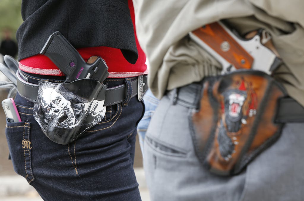 AUSTIN, TX - JANUARY 1: Art and Diana Ramirez of Austin with their pistols in custom-made holsters during and open carry rally at the Texas State Capitol on January 1, 2016 in Austin, Texas. On January 1, 2016, the open carry law takes effect in Texas, and 2nd Amendment activists hold an open carry rally. (Photo by Erich Schlegel/Getty Images)