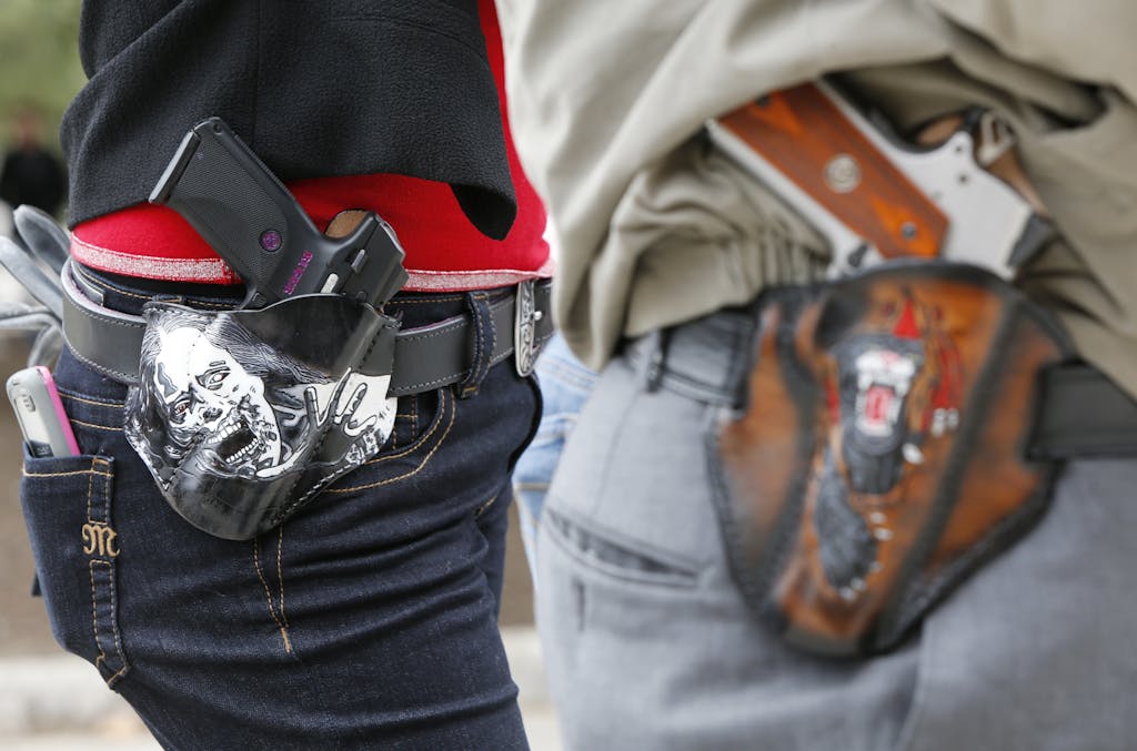 AUSTIN, TX - JANUARY 1: Art and Diana Ramirez of Austin with their pistols in custom-made holsters during and open carry rally at the Texas State Capitol on January 1, 2016 in Austin, Texas. On January 1, 2016, the open carry law takes effect in Texas, and 2nd Amendment activists hold an open carry rally. (Photo by Erich Schlegel/Getty Images)