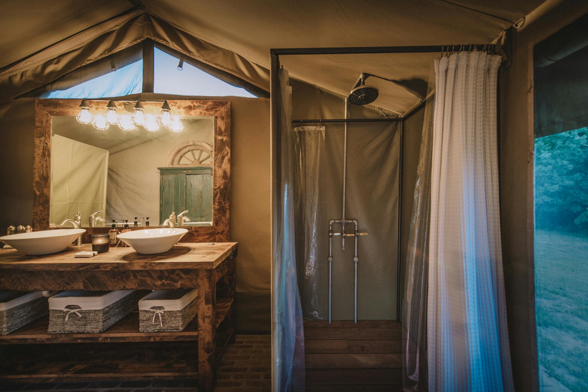 Sink, shower, and mirror of the indoor bathroom of the Safari Tent.