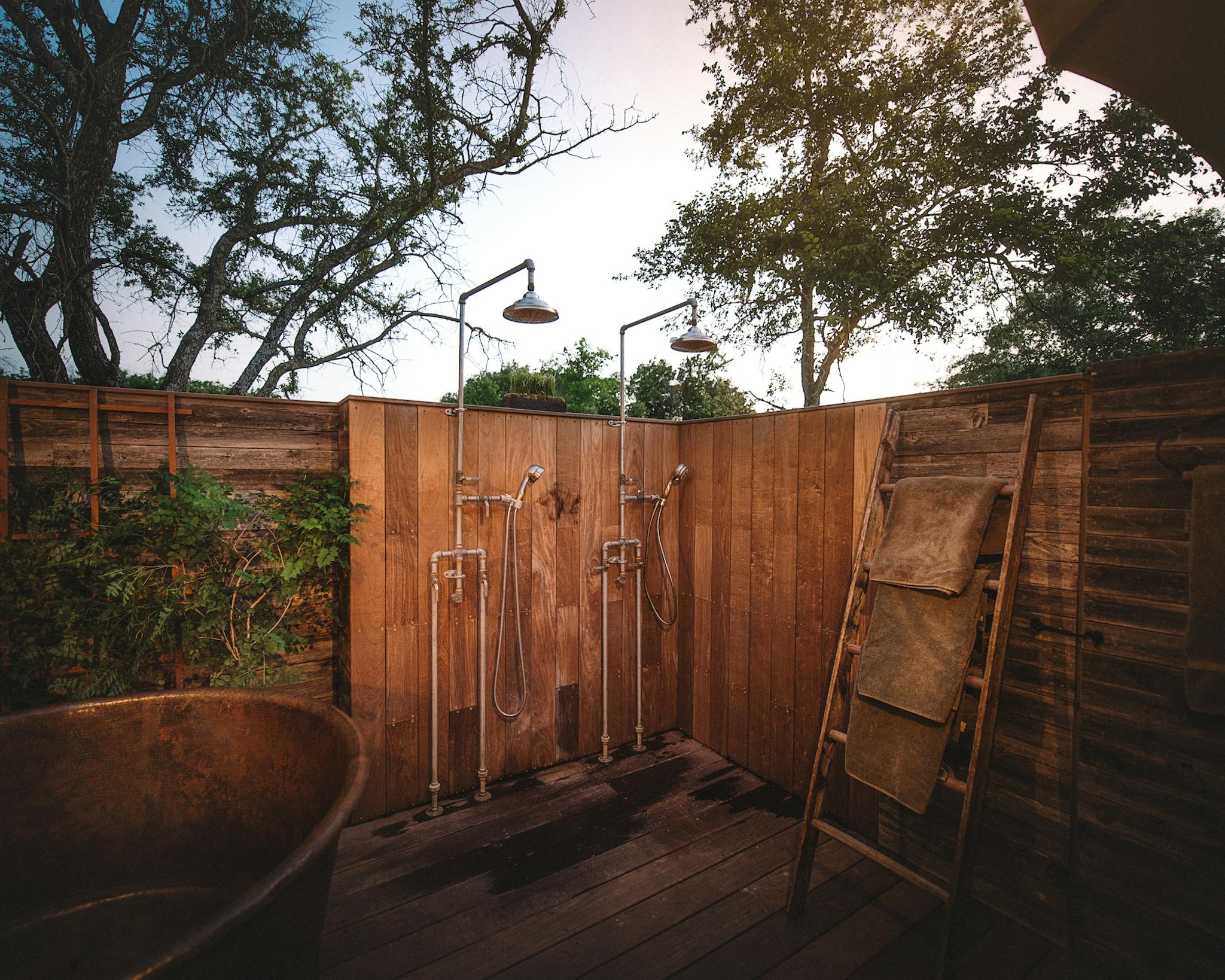 Outdoor showers surrounded by wooden fence.
