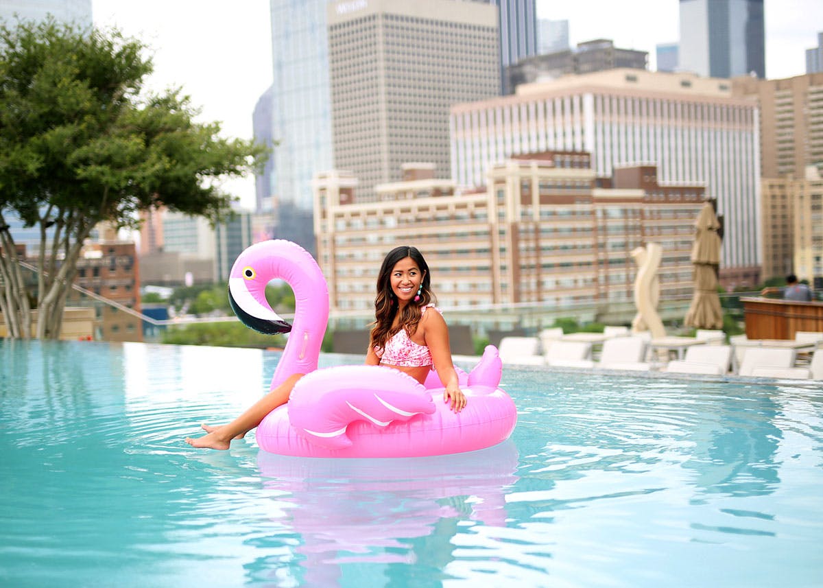 Women on a pink flamingo float in the Omni Downtown Dallas hotel. 