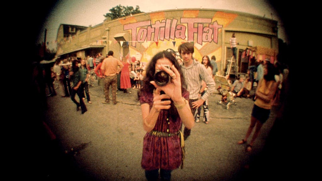 Fish eye photo of a person with a camera at the Anderson Fair block party. 