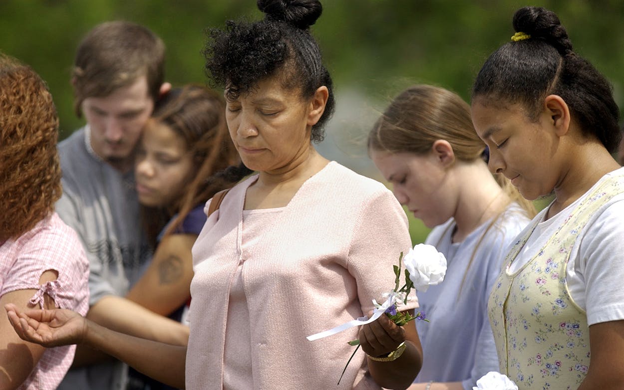 Sheila Martin, center, and her daughter Kimberly, far right, join in prayer at the grave site of some of the Branch Davidians, Saturday, April, 19, 2003 in Waco. The service was part of a 10-year-memorial service honoring the memory of those who died in the fire.