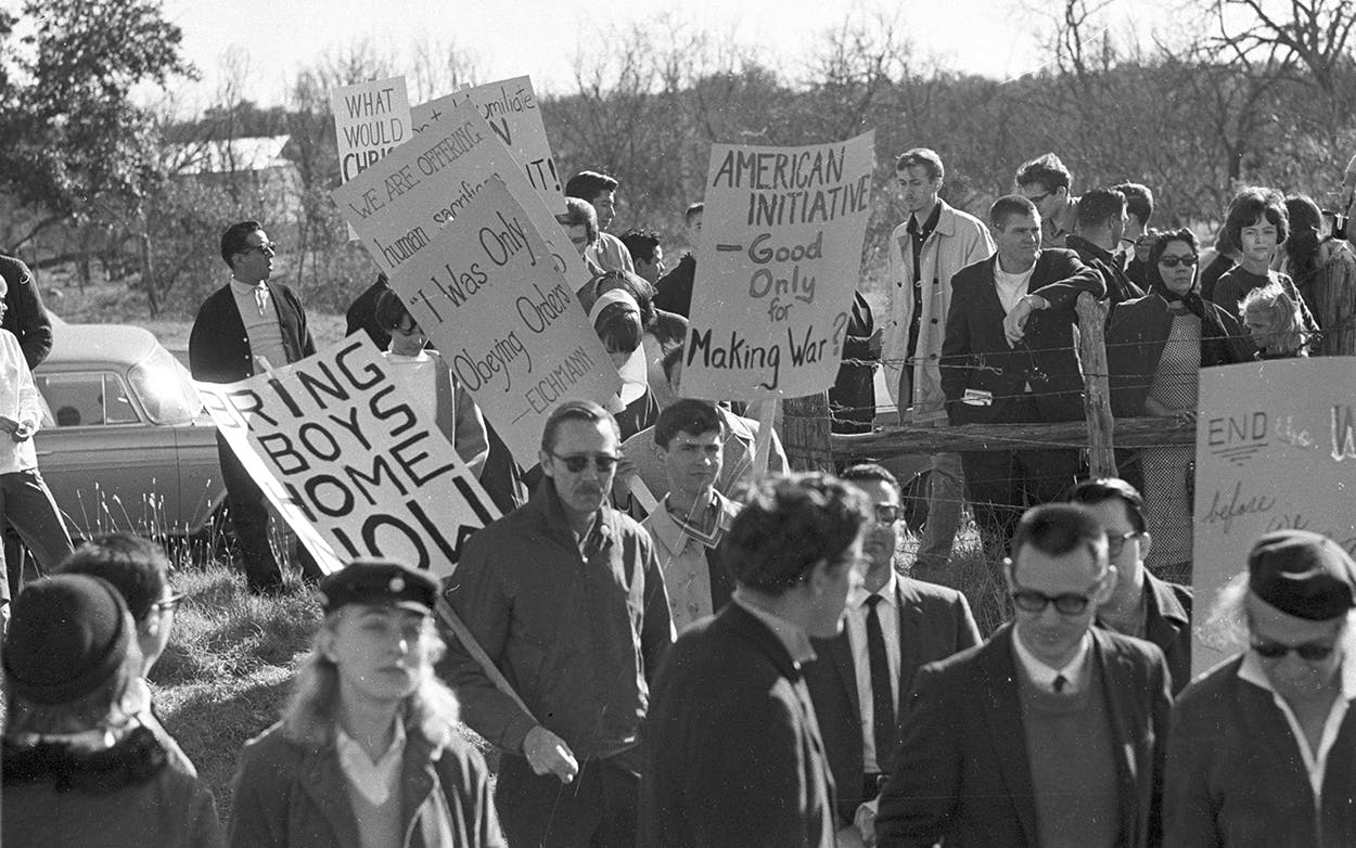 Anti-Vietnam War protesters, some carrying signs, rally on Texas Ranch Road 1, which leads to U.S. President Johnson's LBJ Ranch, in Stonewall, Texas, on Dec. 26, 1965.