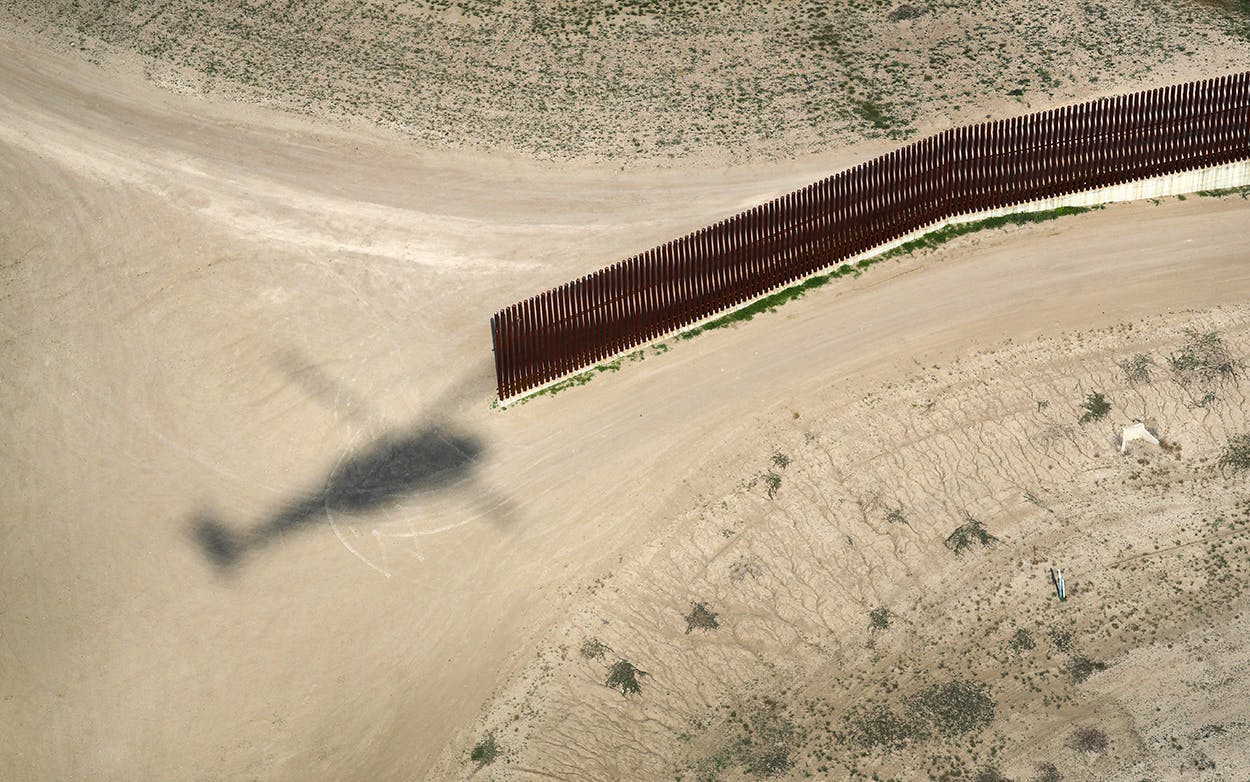 A shadow from a U.S. Air and Marine Operations helicopter passes along the U.S.-Mexico border fence on February 21, 2018 in McAllen.