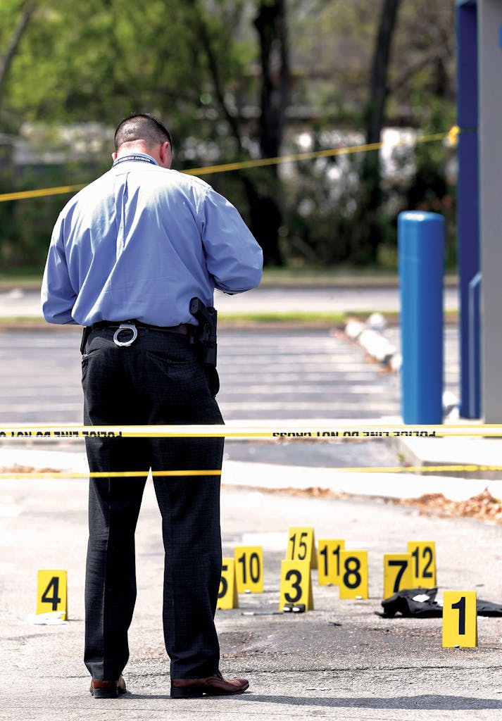 Officer examining markers at the crime scene.
