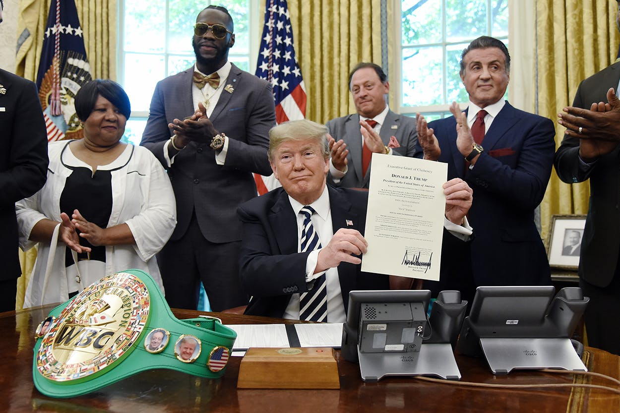 US President Donald Trump holds a signed Executive Grant of Clemency for boxer 'Jack Johnson ' in the Oval Office of the White House on May 24, 2018 in Washington, DC. Attending the event from L to R Linda Haywood, Great great niece of Jack Johnson, Deontay Wilder, Keith Frankel, Sylvester Stallone, and Lennox Lewis.