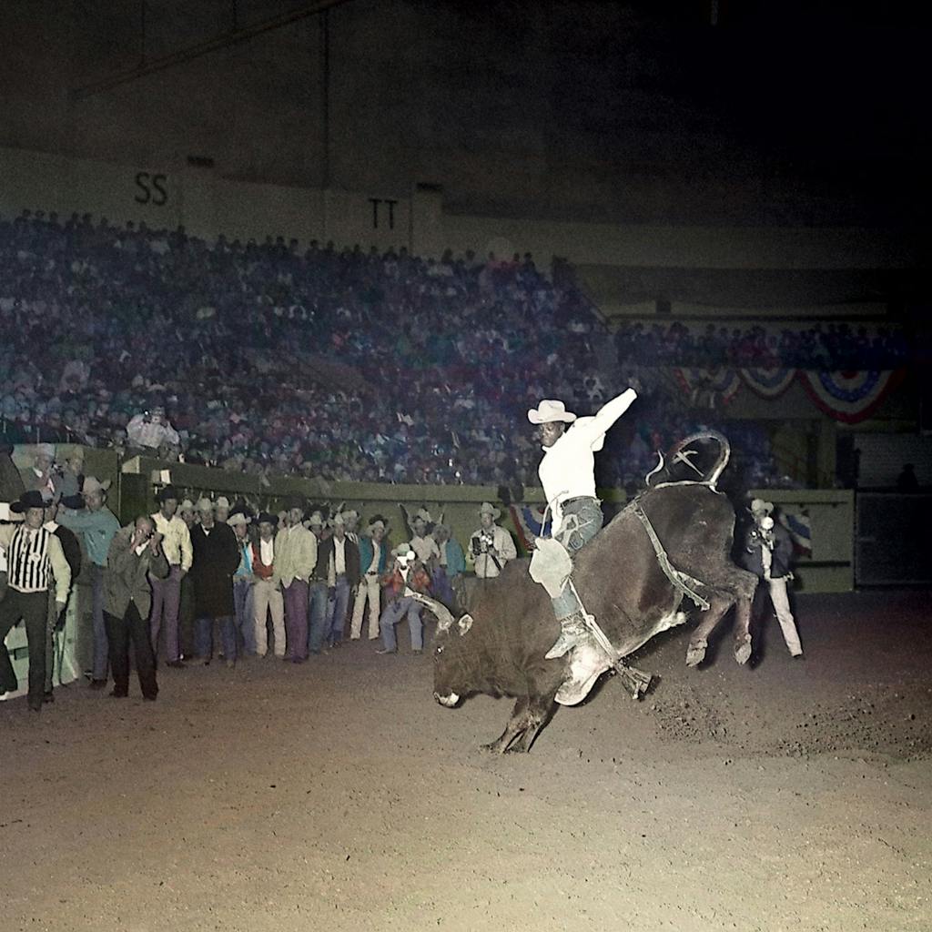Myrtis Dightman riding a bull at the National Finals Rodeo