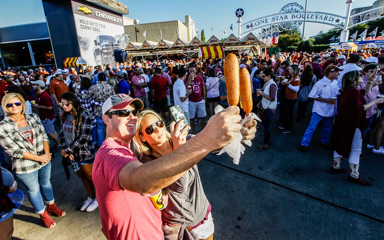 Gwin Huey, right, and her husband Ryan Huey make a photo of their corn dogs at the state fair before an NCAA college football game Saturday, Oct. 8, 2016.