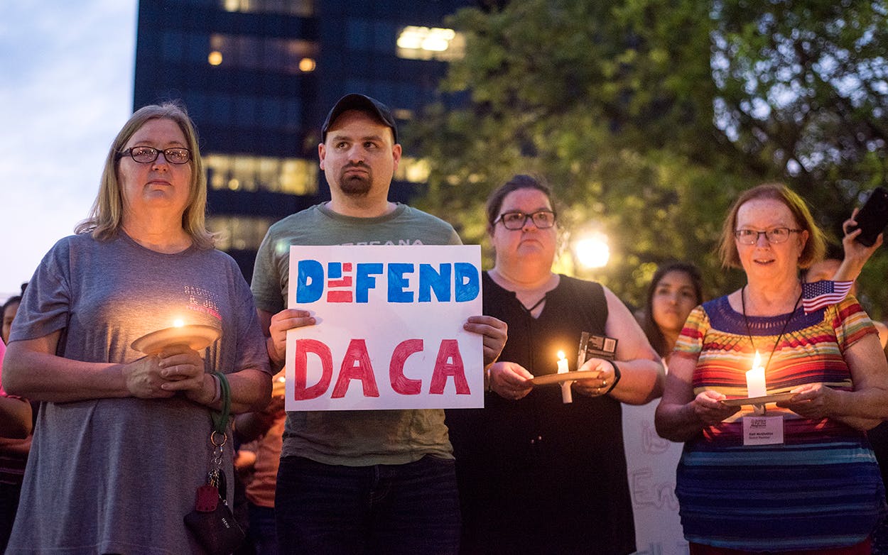 Martha Waggonner, Walker Waggonner, Katie Powell and Gail McGlothin stand in silence holding candles and signs during a silent vigil in honor of Deferred Action for Childhood Arrivals (DACA) at T.B. Butler Fountain Plaza in Tyler, Texas, on Tuesday, Sept. 5, 2017.